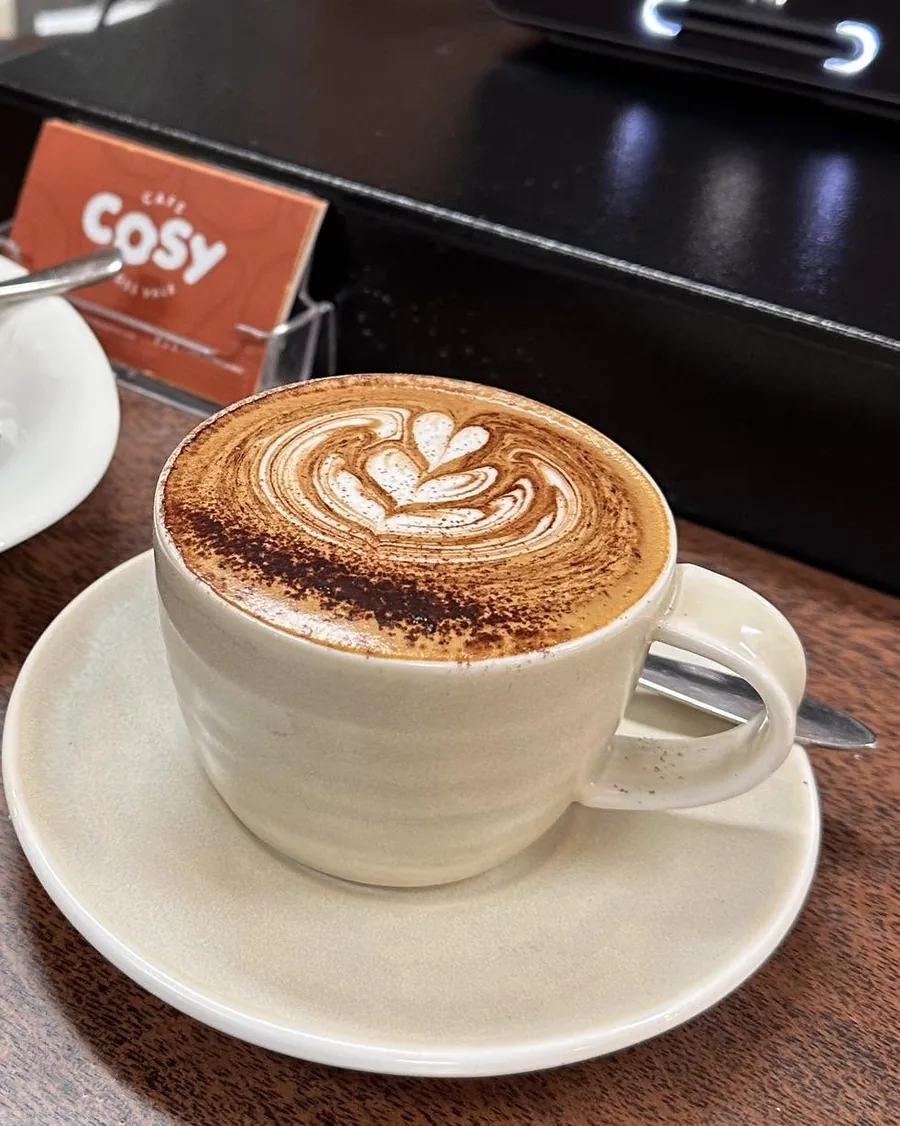 Branded Cafe Cosy Moss Vale takeaway coffee cup held in hand